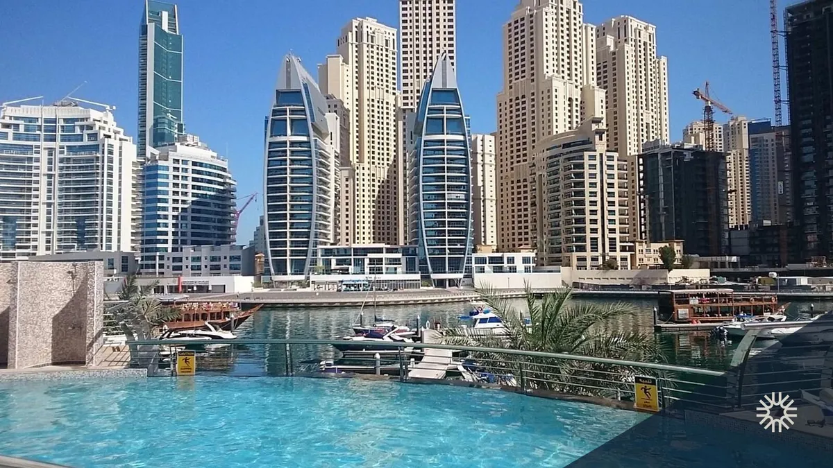 Residential towers and boats on the Dubai Marina canal, a popular area to buy apartment in Dubai Marina