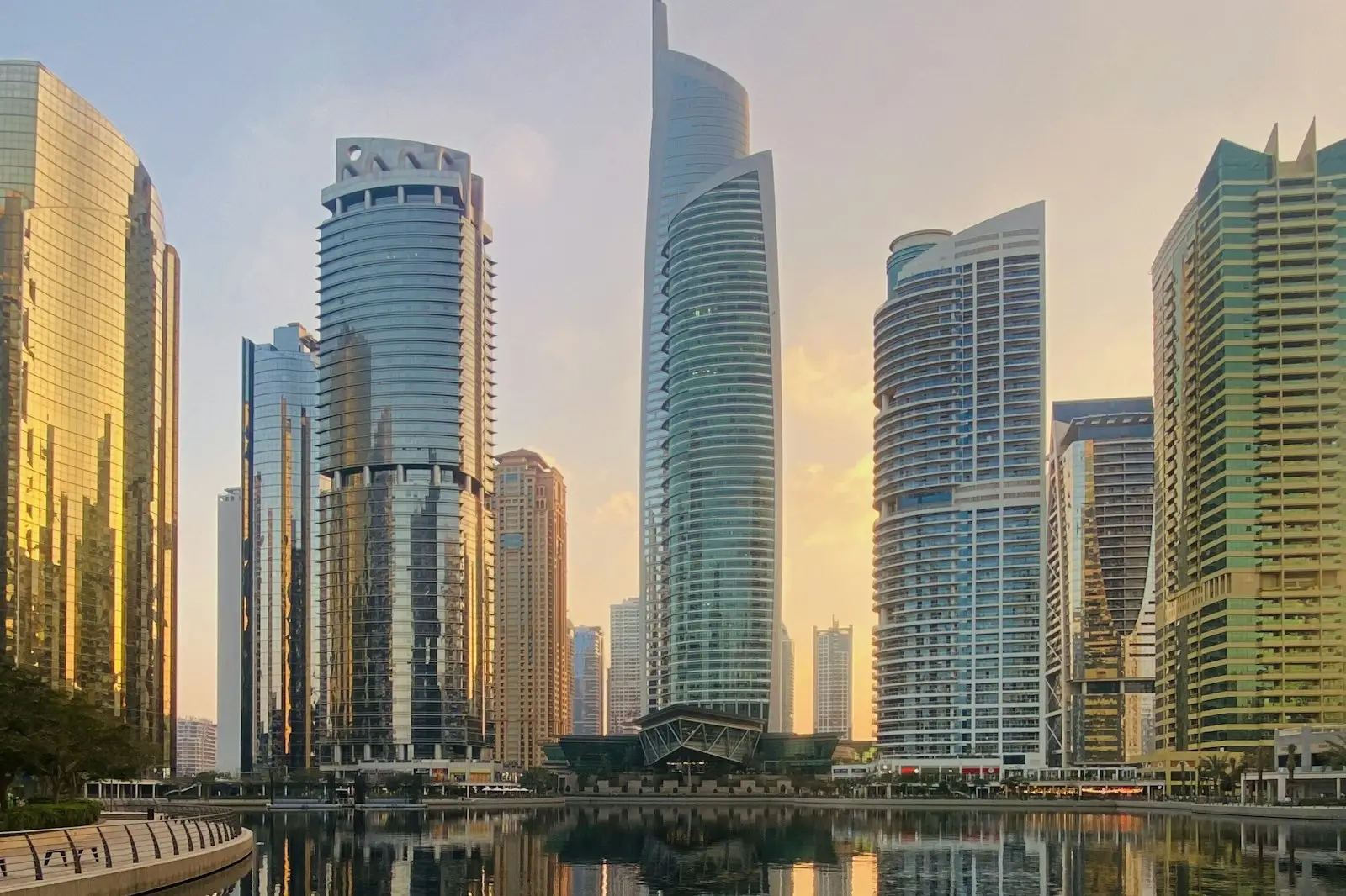 Dubai Marina vs JLT: towers reflected in a JLT lake at sunrise