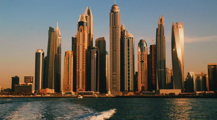 Dubai Marina vs JLT: Dubai Marina towers at sunset seen from the water
