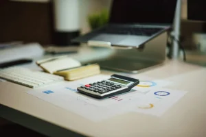Calculator and laptop on a desk for working out property tax in Dubai and ownership costs