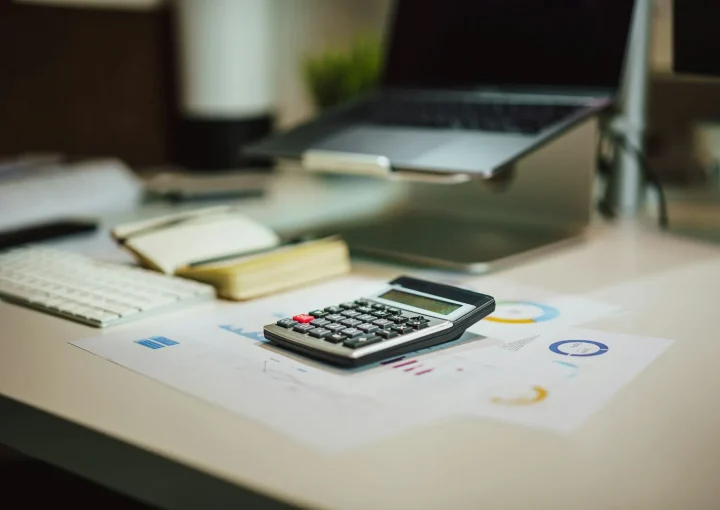 Calculator and laptop on a desk for working out property tax in Dubai and ownership costs