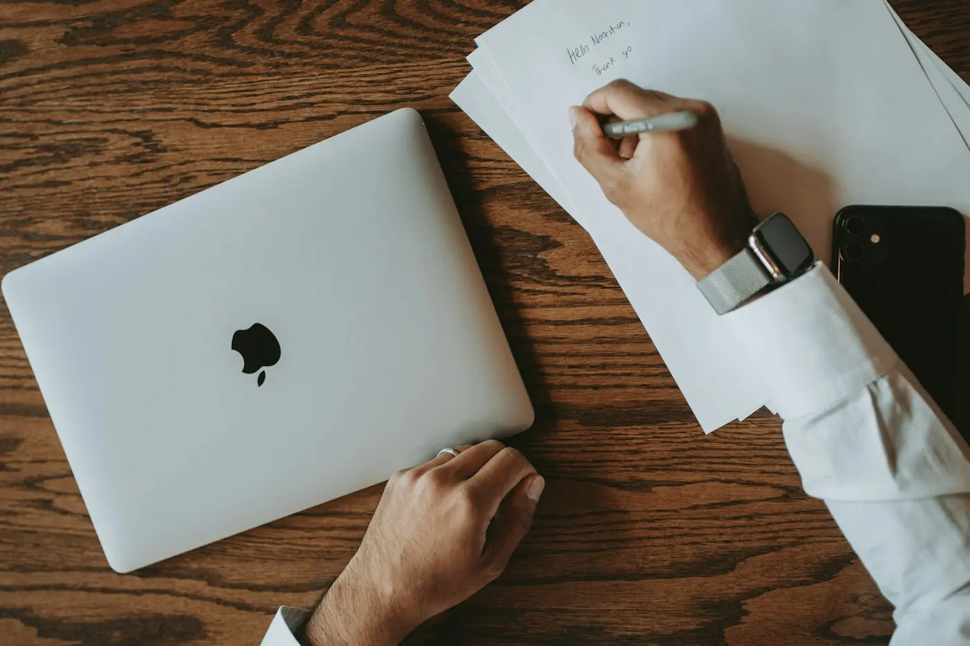 Remote property purchase Dubai: a person signing documents beside a closed laptop