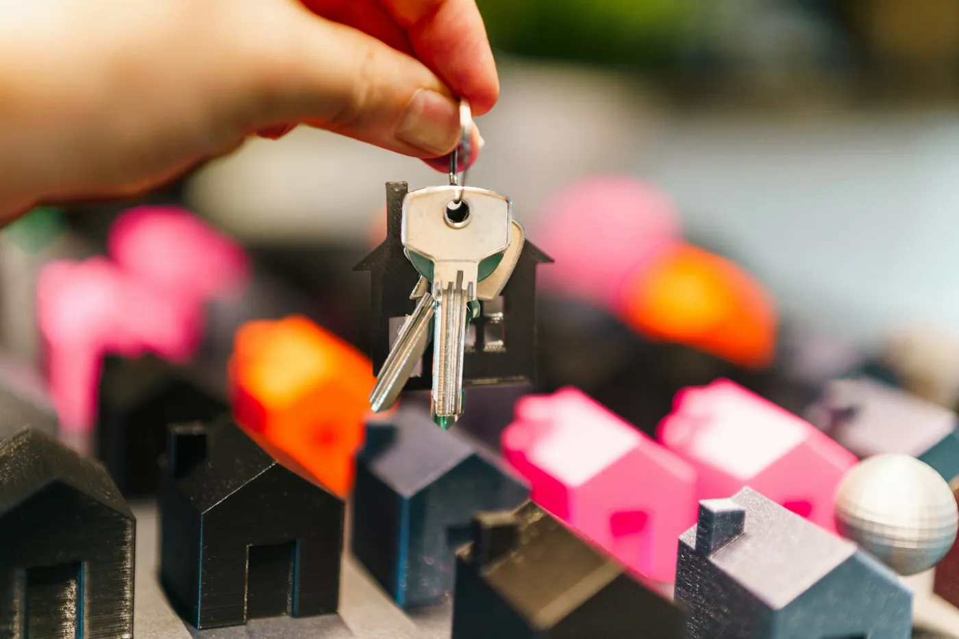 Off-plan resale in Dubai: house keys held above miniature homes