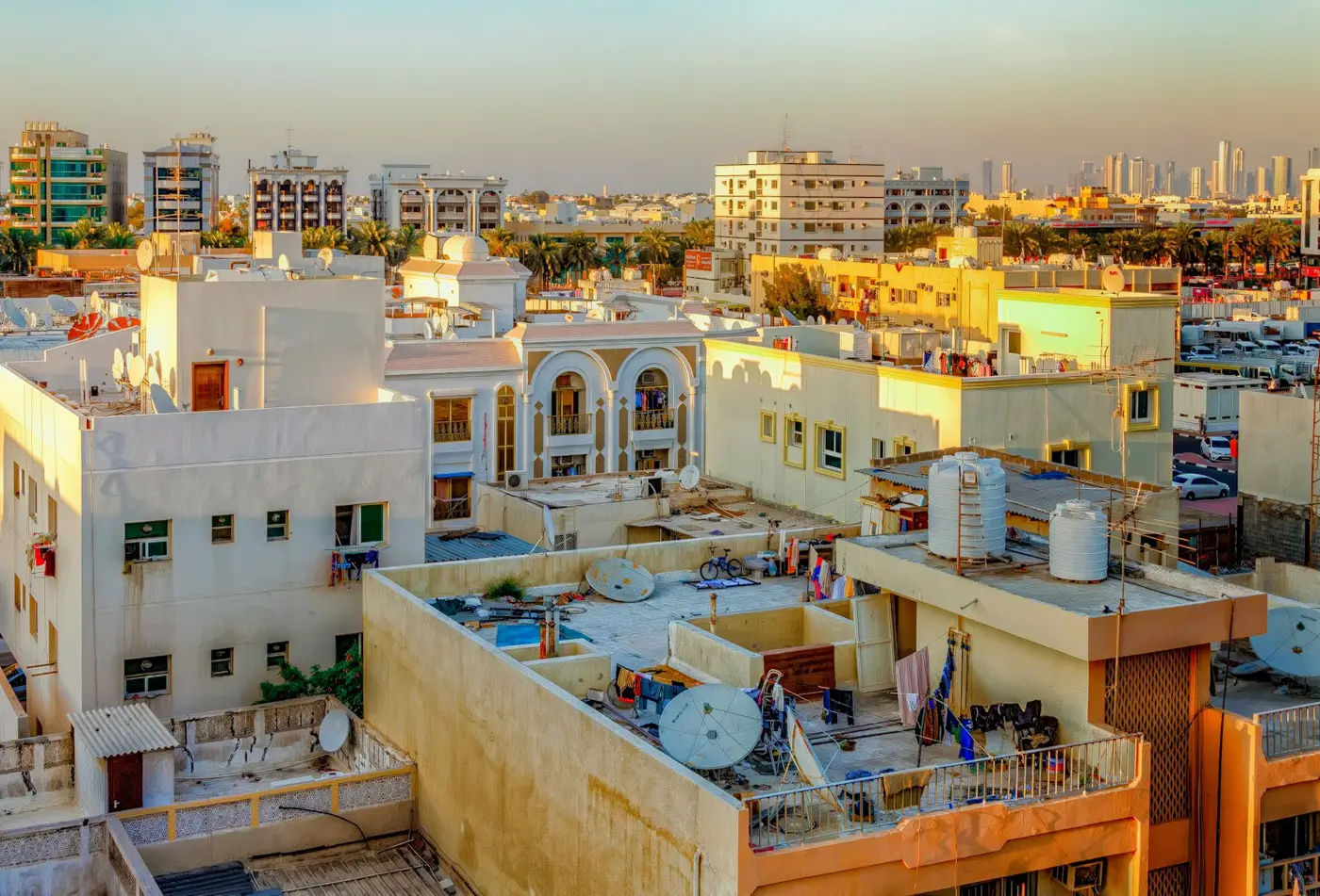 Selling property in Dubai: rooftops of older Dubai apartment buildings with the skyline behind